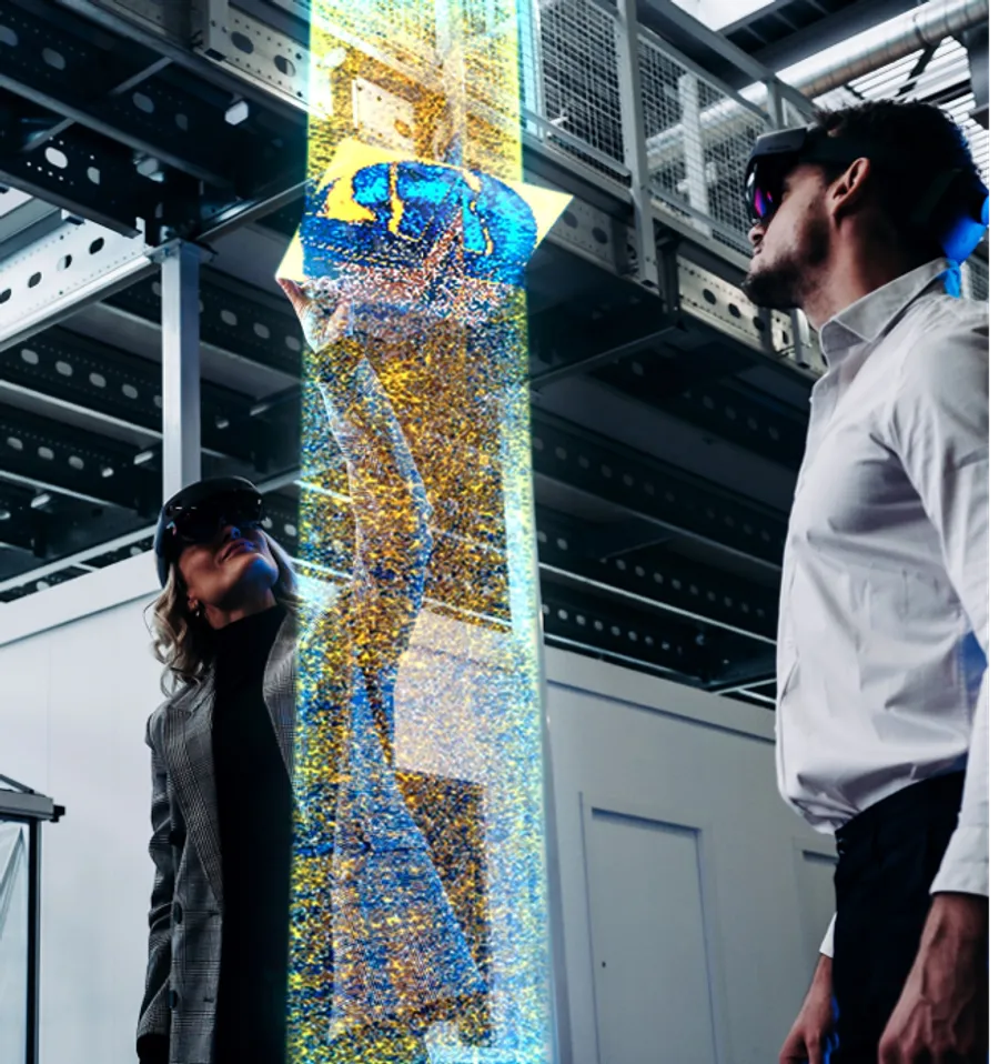 Promotional illustration of two viewers examining a vertical CT volume at an enlarged scale
